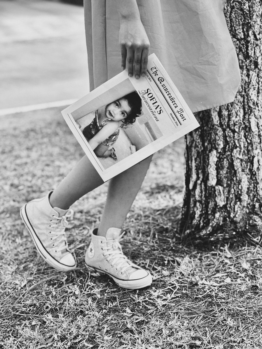 Quinceañera con tenis y un periódico con su foto de bebé